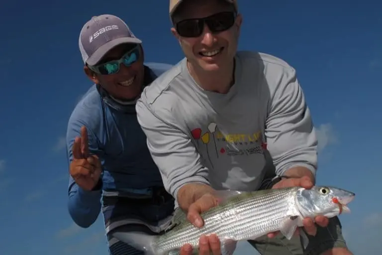 Belize fishing guide Abner Marin with a satisfied client about to release a bonefish. Photo by Erik Hoffner for Mongabay.