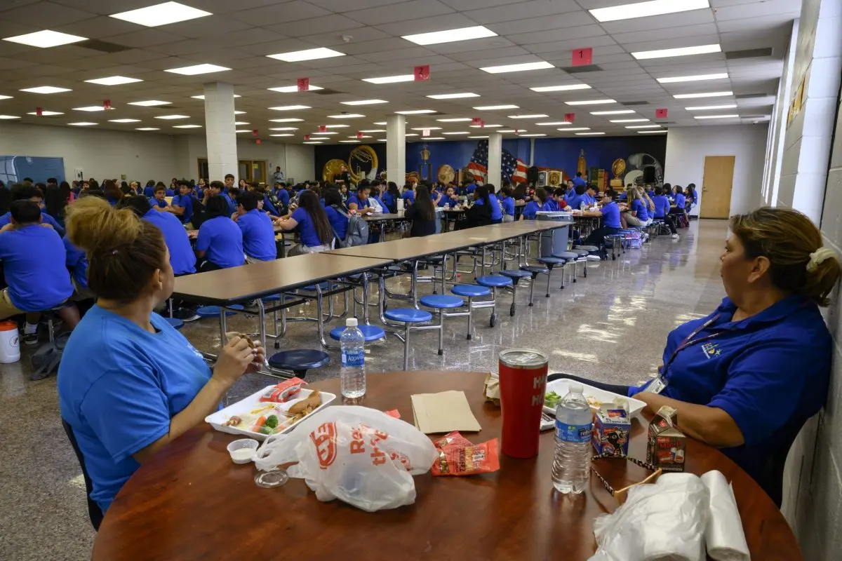 Bonham Middle School employees watch as students begin to gather for lunch in the school’s cafeteria on Sept. 13, 2023 in Odessa.
