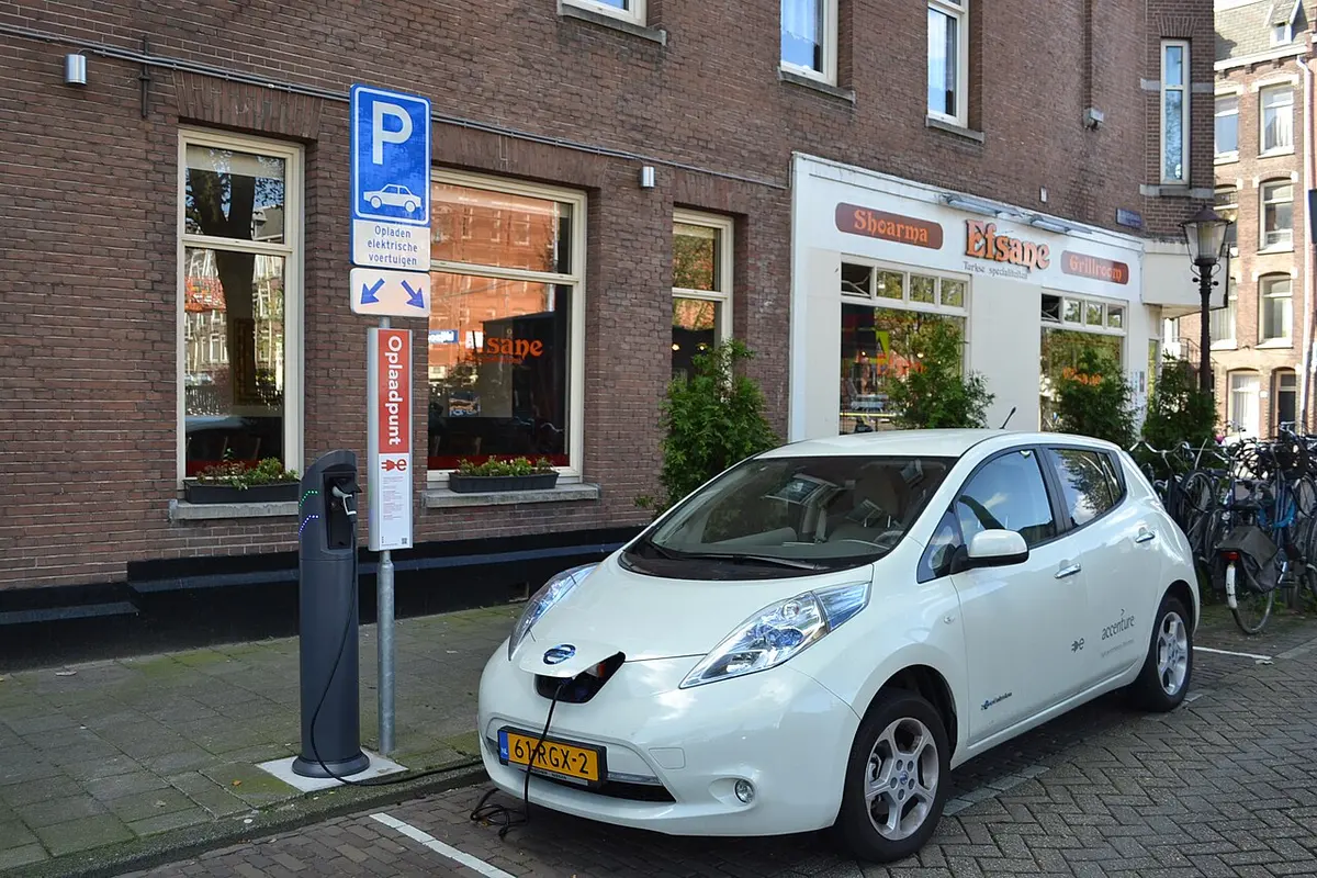 A Nissan Leaf electric car recharging at an on-street public charging station in Amsterdam