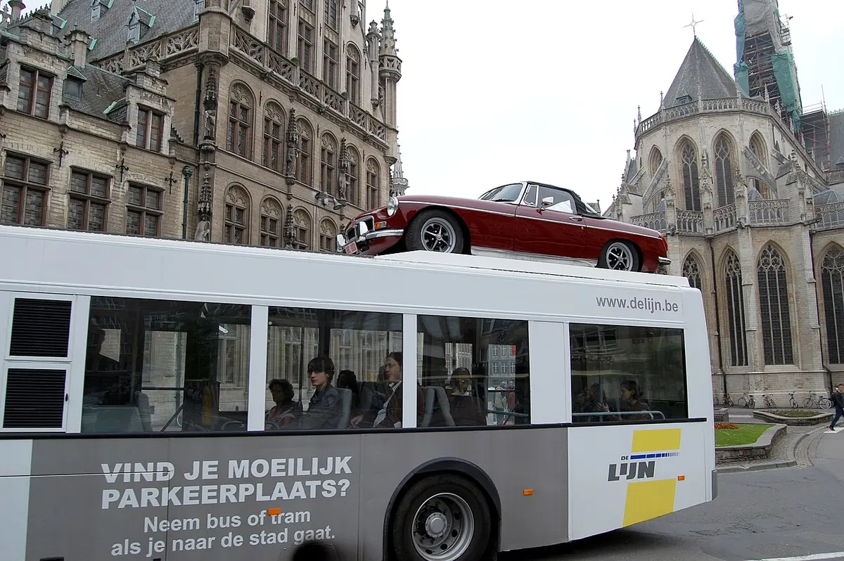 The Belgian bus company De Lijn parked a red MGB on top of one of their buses.