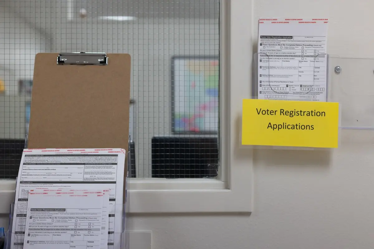 Voter registration applications hang in a holder inside of the Elections Office in Fredericksburg on March 5, 2024. Maria Crane/The Texas Tribune