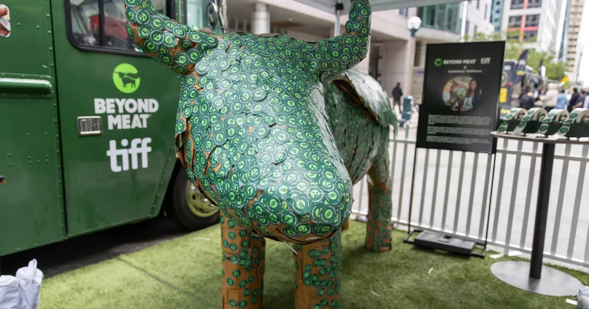 A large cow figure with green stickers all over Credit: Mat Hayward/Getty Images via Sentient.