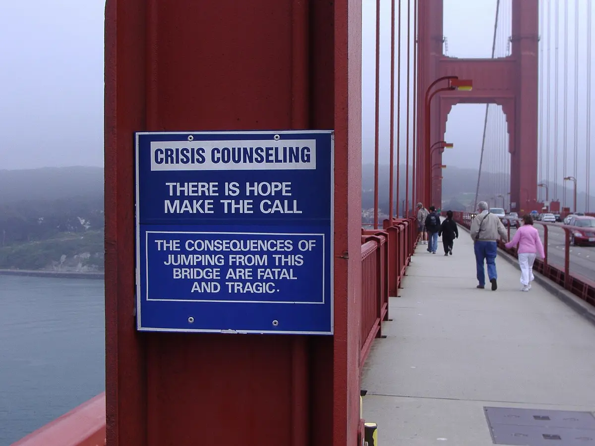 A suicide prevention sign on California's Golden Gate Bridge. Professor Siegel noted guns to be a more lethal method than this famed and high-profile example, and theorised this accounted for household gun ownership being a stronger predictor of successful suicides than the rate of failed suicide attempts.Image: Eduardo Manchon via Panaramio..