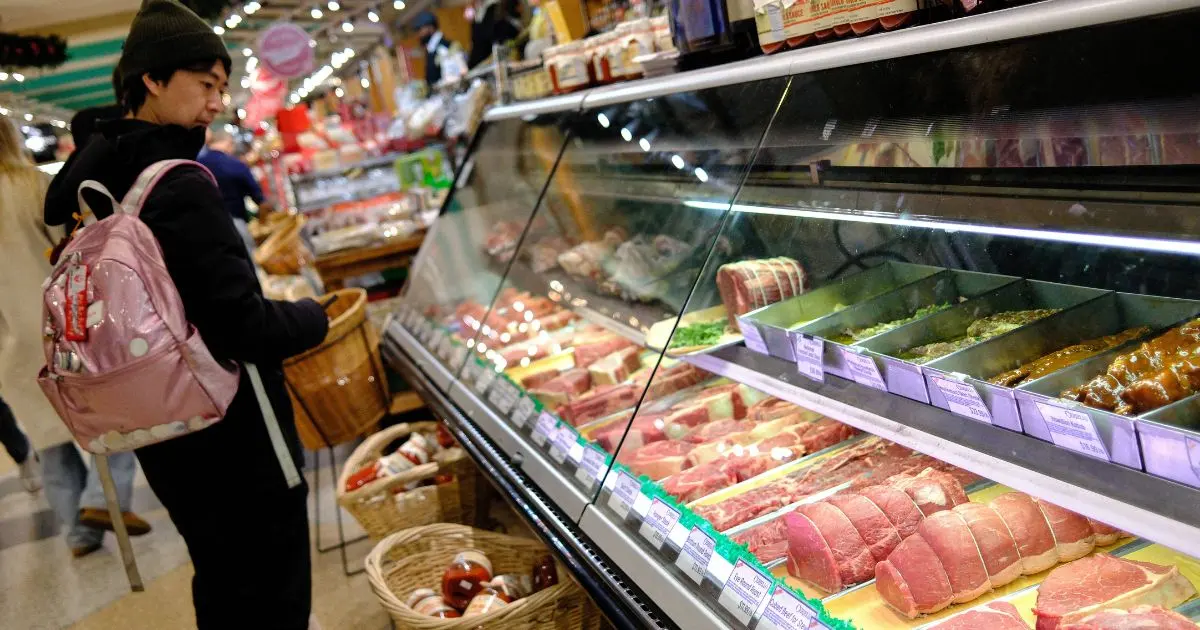 A man shops for meat in a grocery store. Credit: CHARLY TRIBALLEAU / AFP via Getty Image via Sentient.