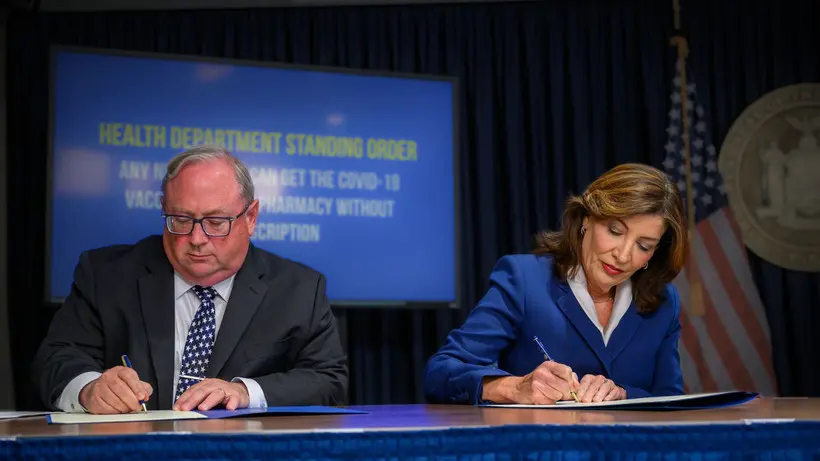 Governor Kathy Hochul and her health department commissioner James McDonald at a desk