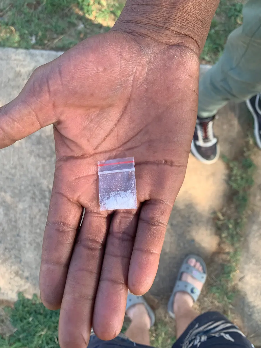 A drug dealer holds up a R50 “baggie” of meth in a northern Tshwane township.