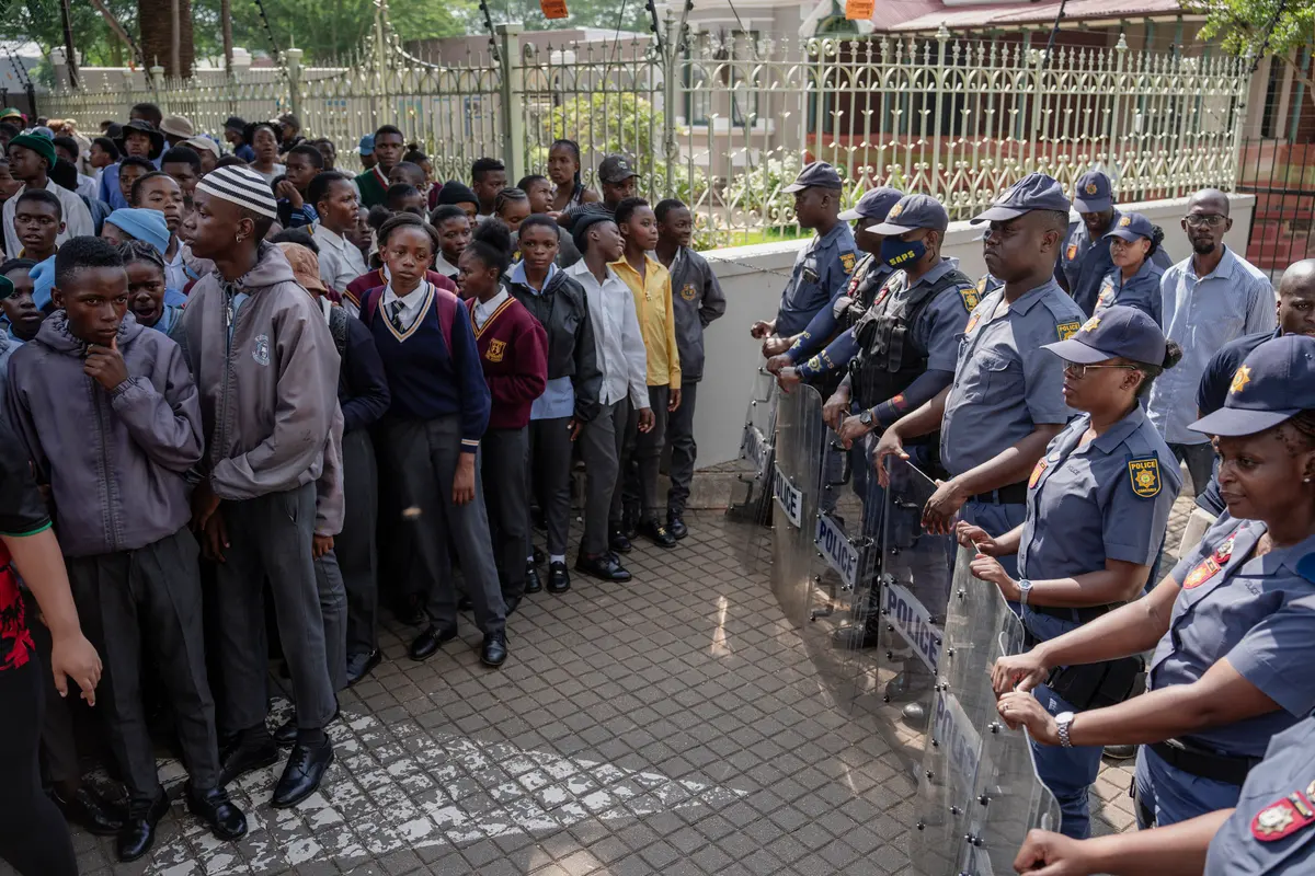 Outside the Department of Basic Education, police formed a barrier with riot shields between the learners and the entrance of the office.