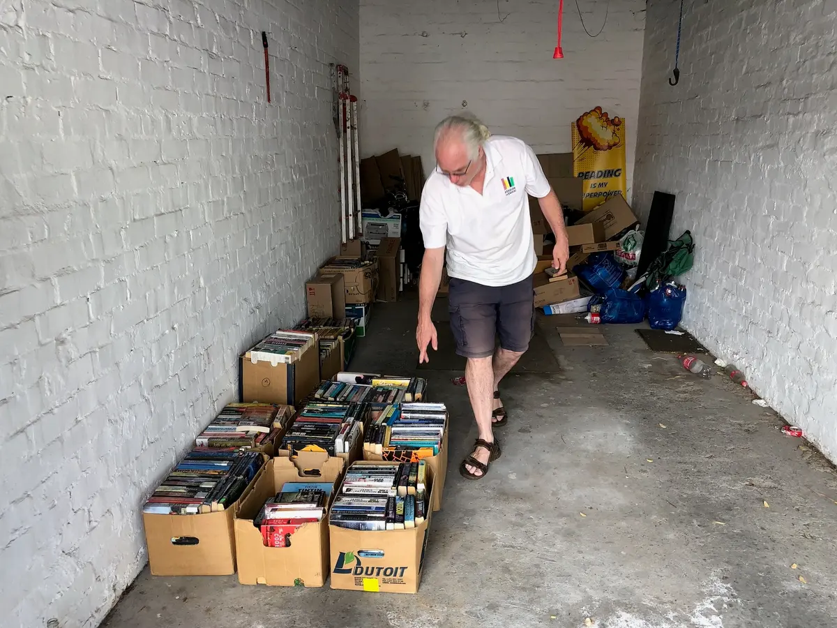 Last year, high school English teacher Nigel Mortley started a mobile library called Reading is Kwaai to promote reading at high schools that have no libraries. Mortley above with some of the boxes of books he has has in his garage. Photo: Mary-Anne Gontsana