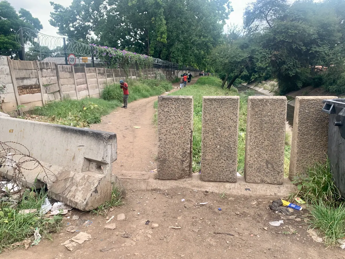 The pathway to 16 Passage, along the bank of the Apies river. It’s a place filled with beneficiaries of the TB HIV Care centre.