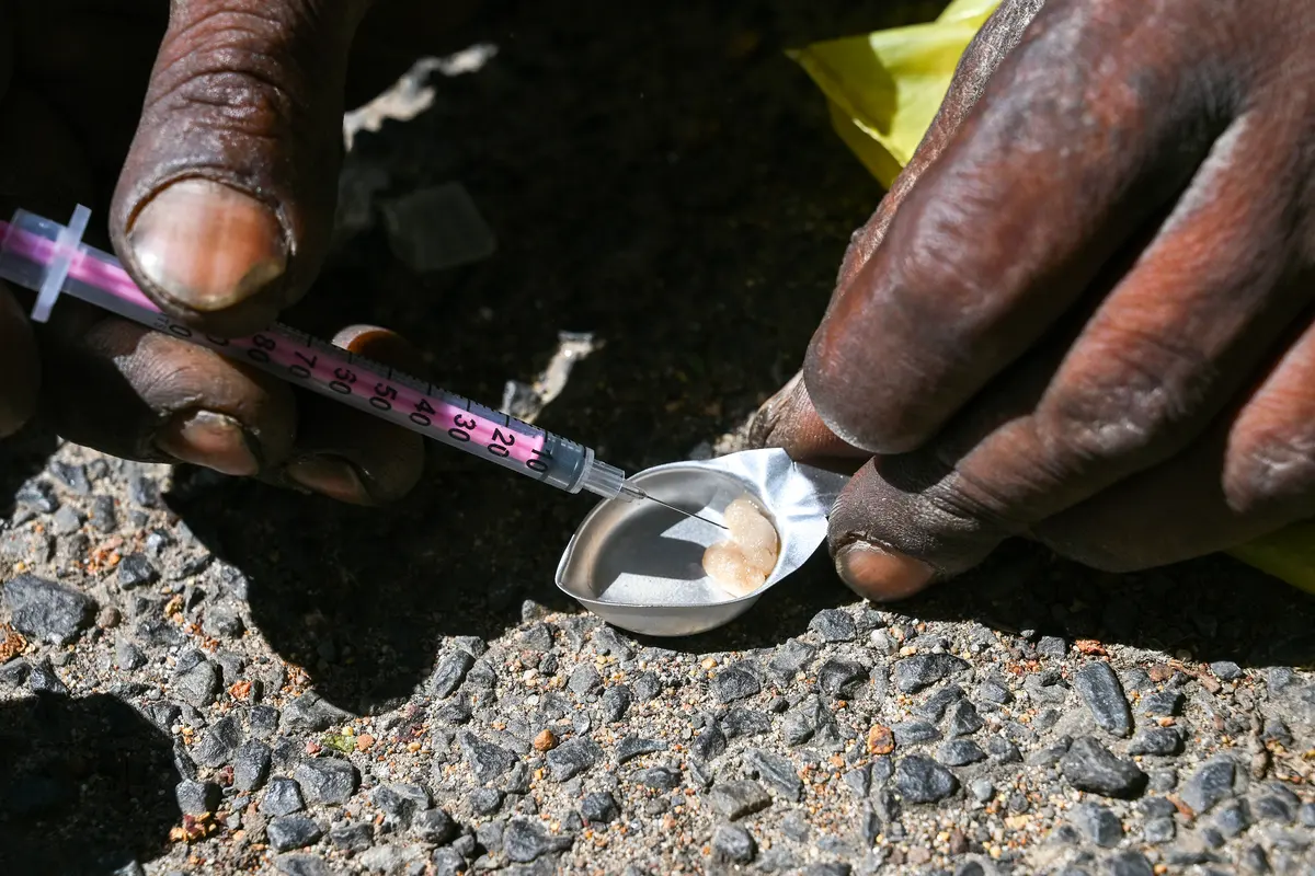 A man prepares a small dose of heroin. Archive photo: David Harrison