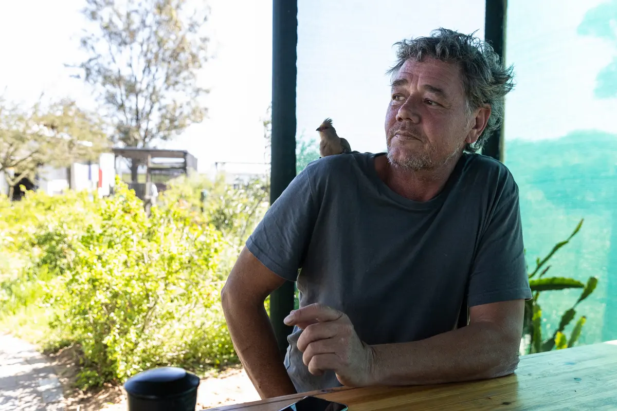 Jacques Nel, founder of the Owl Orphanage in Velddrif, with a red-faced mousebird on his shoulder.